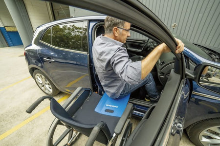 entrada en automóvil de persona con movilidad reducida utilizando tabla de transferencia producto de apoyo